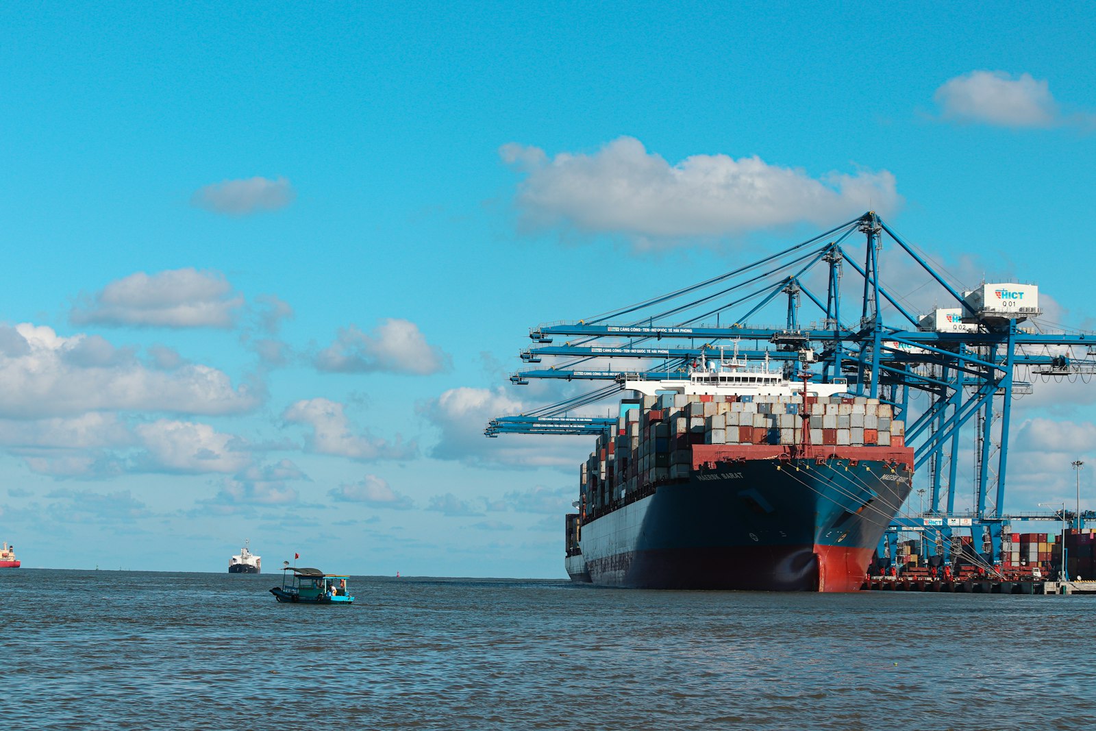 Buque cargando contenedores en puerto